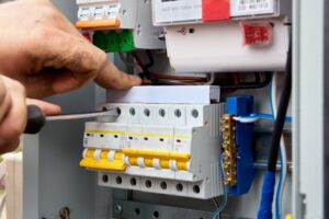 man using screwdriver to upgrade switchboard